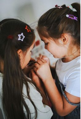 Two young girls looking at their necklaces