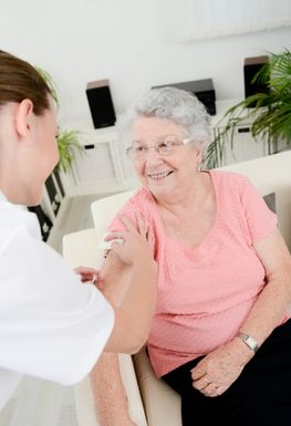 An elderly woman receiving a vaccination