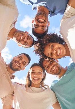 A group of people in a circle looking down into the camera