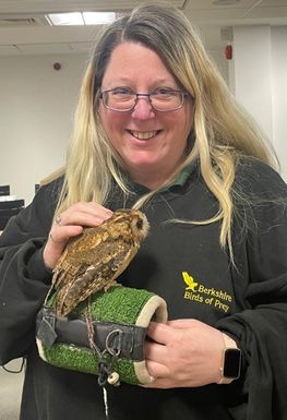 A woman holding a small owl