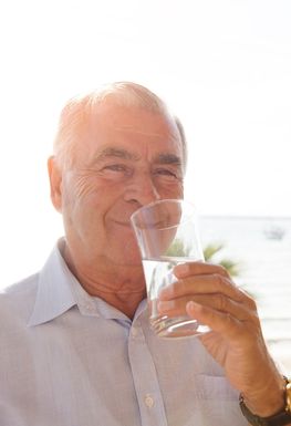 Elderly man drinking a glass of water