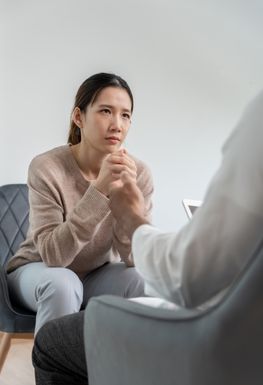 Woman sat on a couch talking.