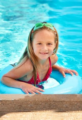 Child swimming in a pool with a rubber ring